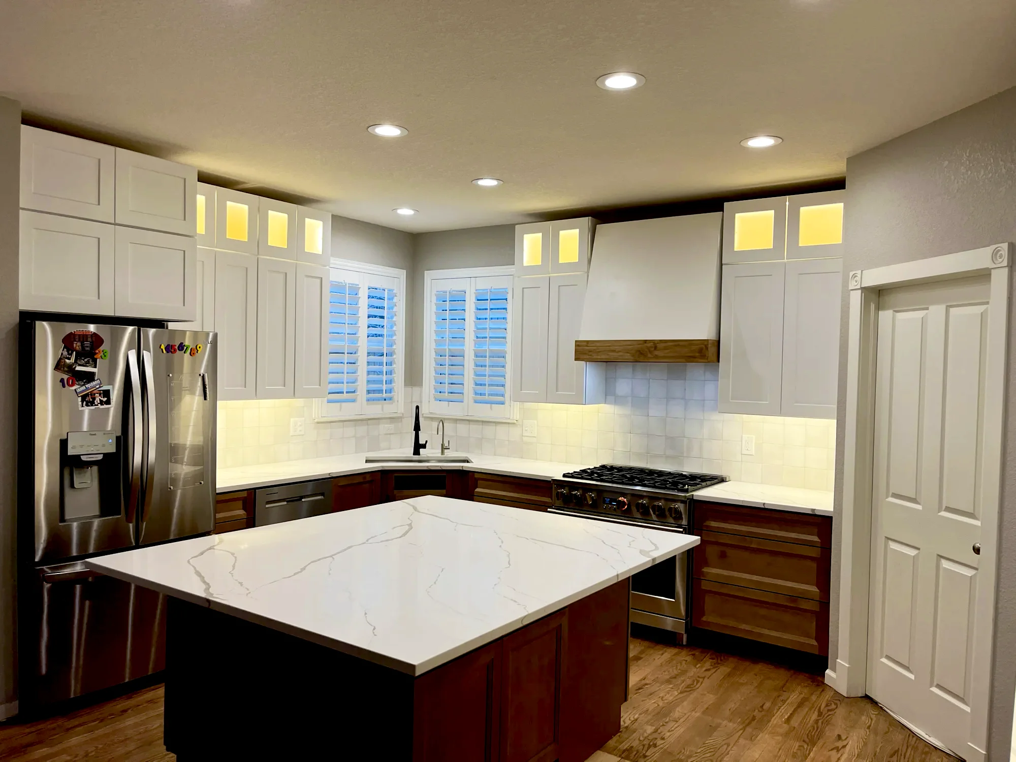 White kitchen with recessed, in-cabinet, and under-cabinet lighting