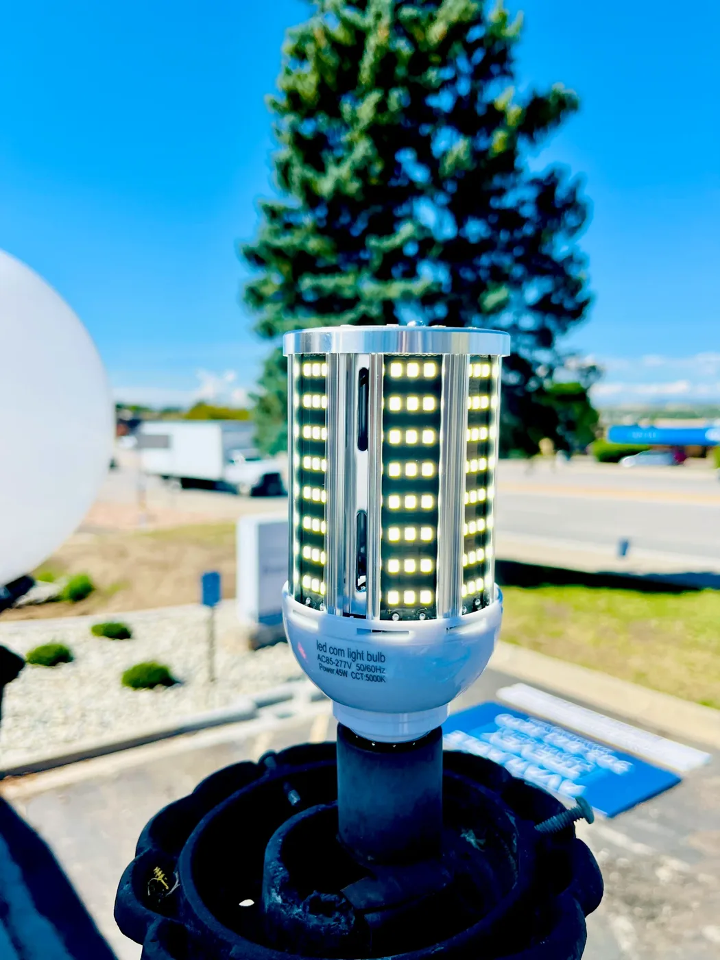 LED corn bulb being fitted into a parking lot light