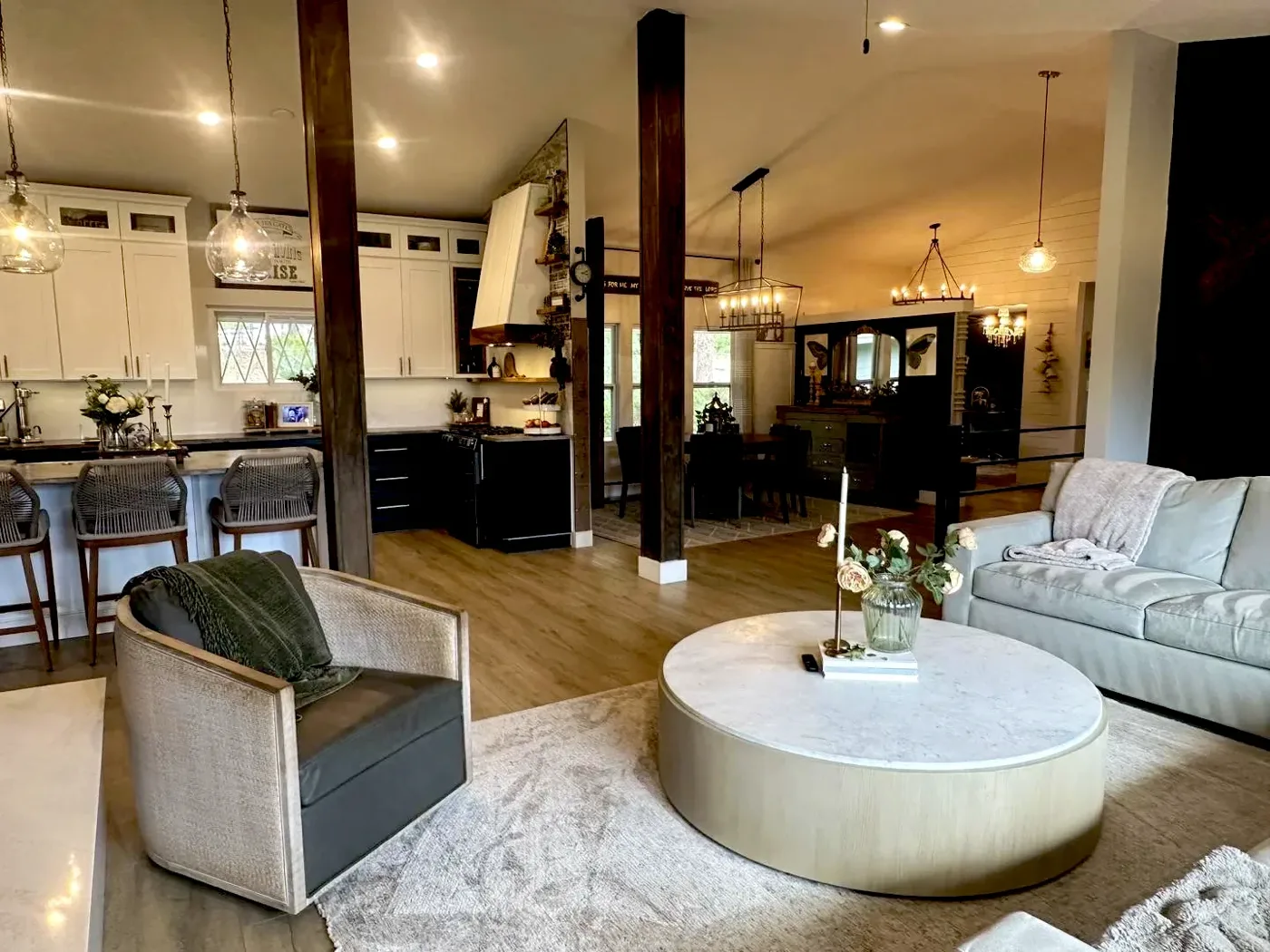 Open-plan great room with pendants, chandeliers, and recessed lighting