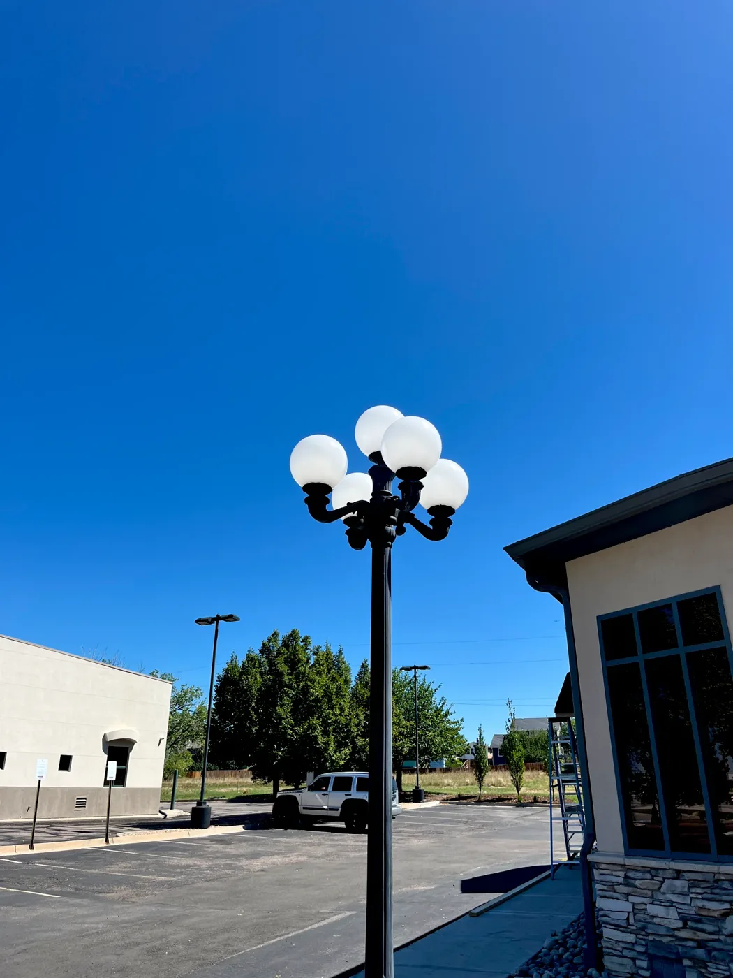 Five-globe parking lot light pole in front of a commercial building